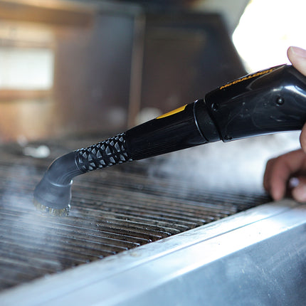Jet nozzle attachment for McColluch products being used for cleaning a grill top. Nozzle is releasing steam and shown in a close up view